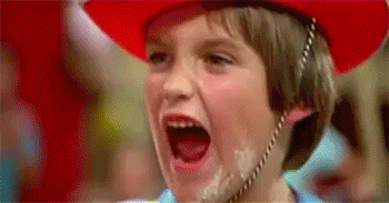 Boy being knocked over by a stream of water from a firehose directed at his face